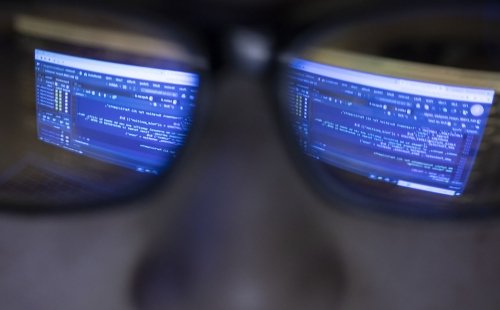 A string of computer code is reflected in the glasses of a researcher at the Marcus Institute for Aging in Boston, MA.