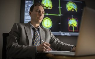 A researcher at the Marcus Institute for Aging Research in Boston, MA studies MRI images of a human brain.