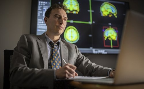 A researcher at the Marcus Institute for Aging Research in Boston, MA studies MRI images of a human brain.